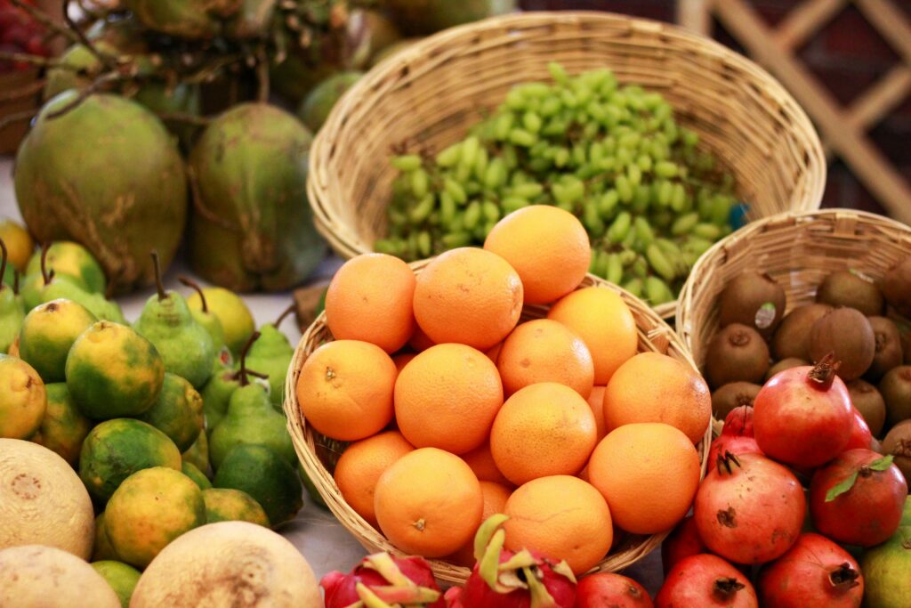 A vibrant display of assorted fresh fruits in baskets at a market in Mumbai, India.